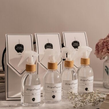 A collection of elegant fragrance bottles paired with gift bags, elegantly arranged on a table.